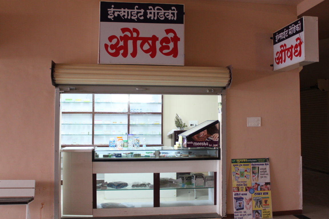 In-house Insight Medico pharmacy frontage with twin bilingual Marathi 'Aushadhi' (medicine) signboards above the dispensing window